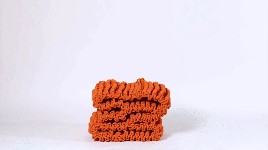 a gif of an orange, knitted nylon rope shelf that expands in a timelapse