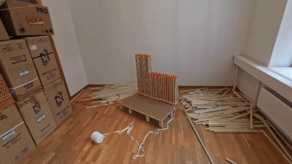 a timelapse gif of a chair being made from heavy-duty plastic and orange nylon rope