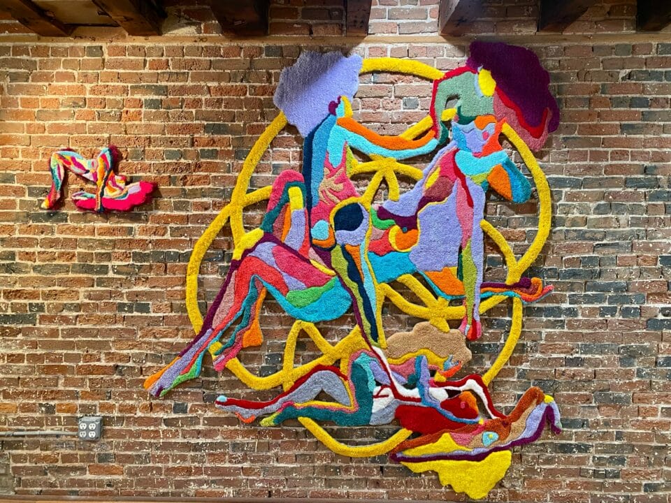 a vibrant abstract, almost figurative wall work with a smaller work on the side