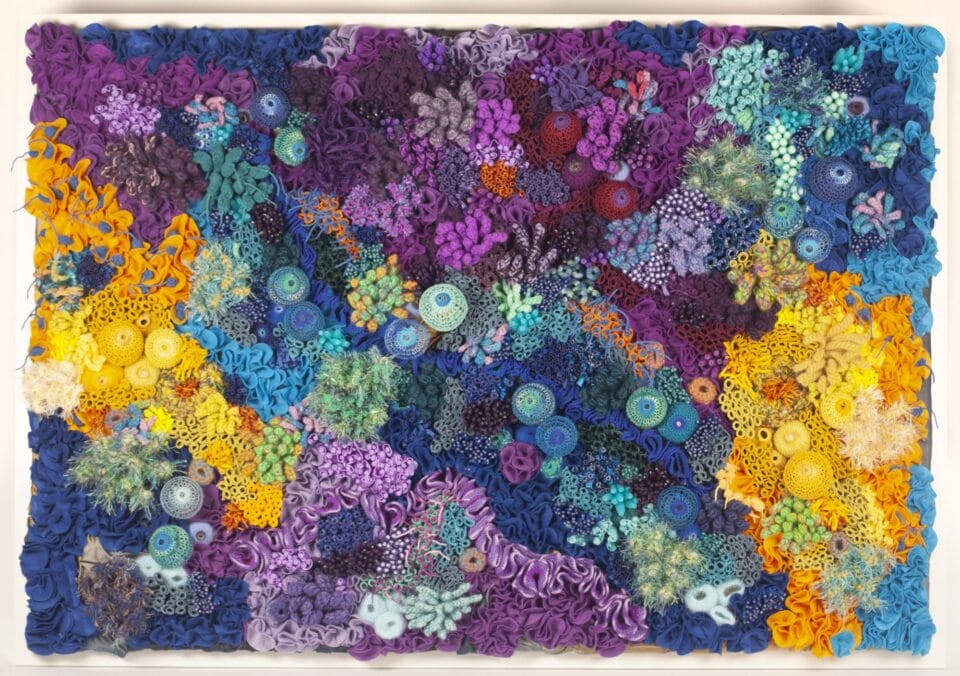 a vibrant fiber work evoking corals, molds, and other organic forms