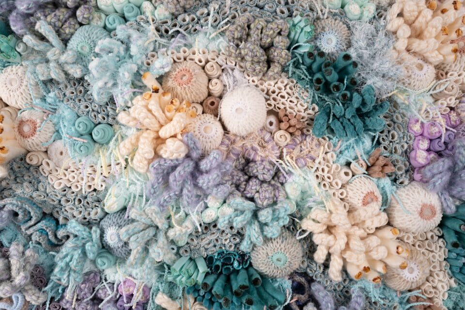 a detail of a vibrant fiber work evoking corals, molds, and other organic forms
