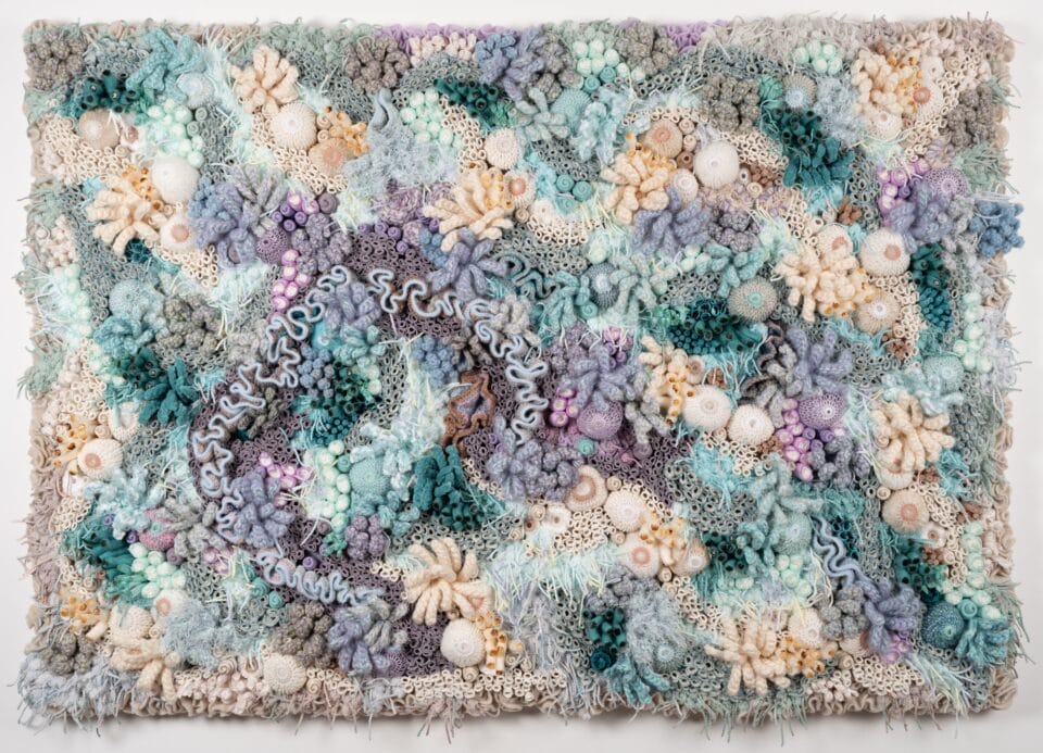 a vibrant fiber work evoking corals, molds, and other organic forms