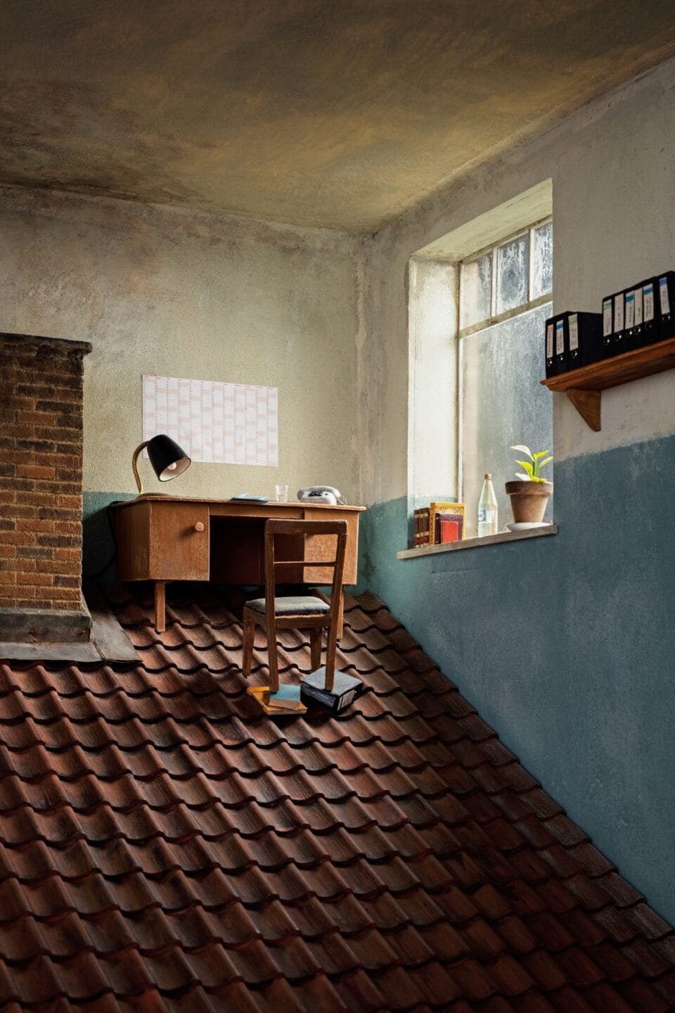 a photo of a miniature set with a desk inside of a room, on a steep tile roof